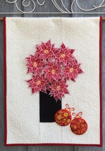 Light-colored quilt with 3D poinsettias