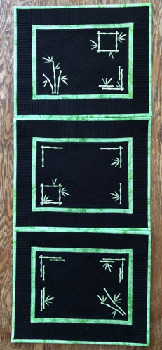 3 black placemats with bamboo embroidery in neon green color.
