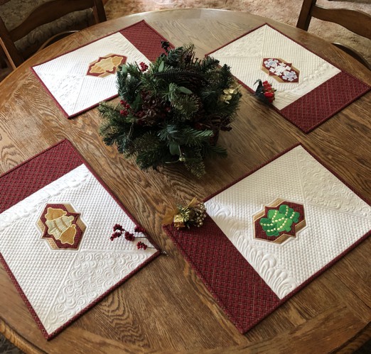 4 quilted placemats with Christmas-themed applique