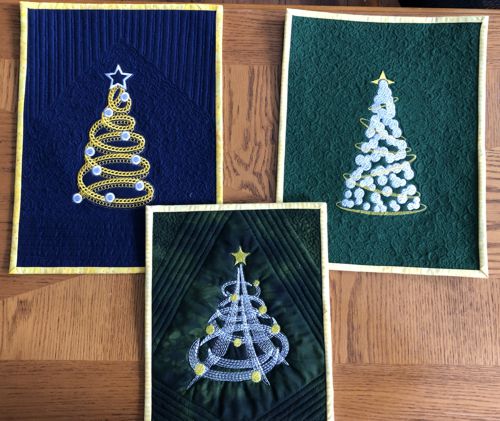 3 small quilts with stitch-outs of the Christmas trees.