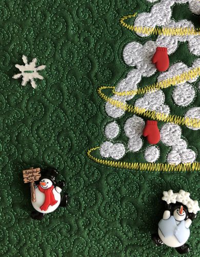 A close-up of the quilt with snowmen buttons.