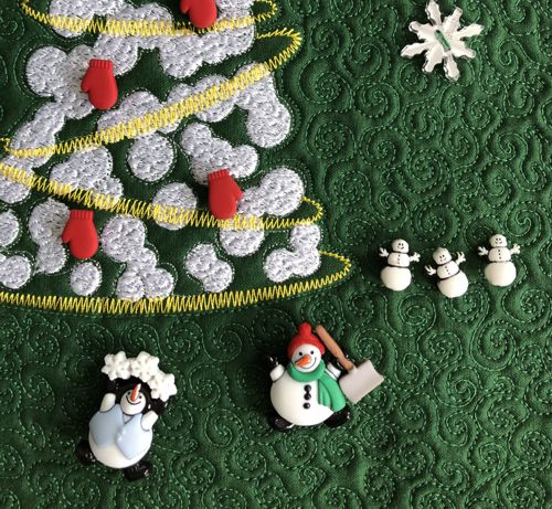 A close-up of the quilt with snowmen buttons.