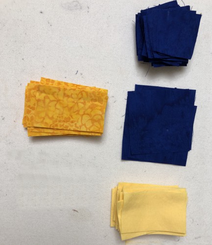 a stack of light and dark yellow strips, and royal blue squares.