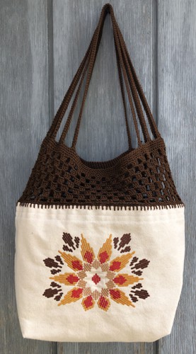 Finished bag with embroidery of flowers in a Southwestern style on the front and bag panels and crocheted top part.