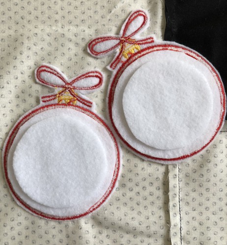 Out of the felt, cut 2 more circles 1/4" smaller than the first ones. Place them on the stitch-outs.