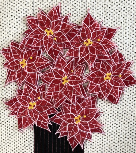 Poinsettia flowers pinned to the quilt.