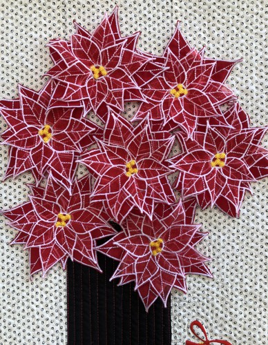 the poinsettia flowers stitched to the quilt.