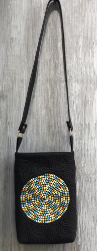 A small black purse with shoulder length handle and spiral embroidery in 6 bright colors.