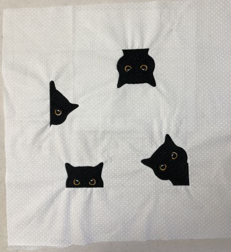 The cats embroidered along the borders of the drawn square.