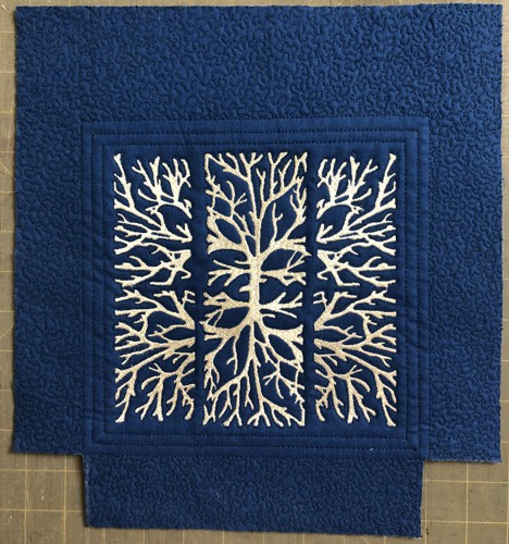 The blue panel with white embroidery and the cut-away lower corners