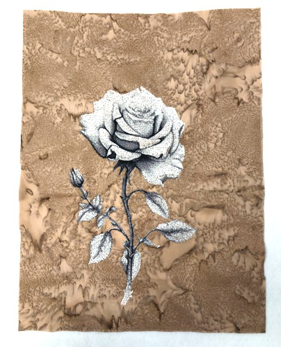 A stitch-out of a rose on the beige background