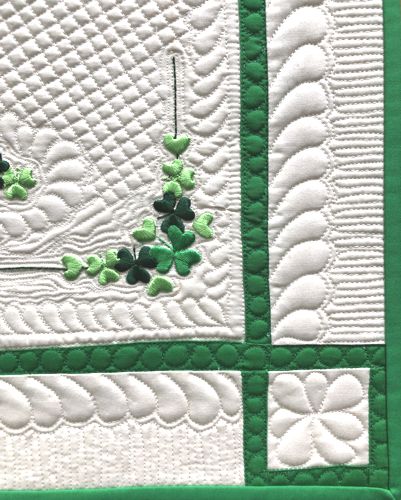 A close-up of the quilting stitches, embroidery and binding.