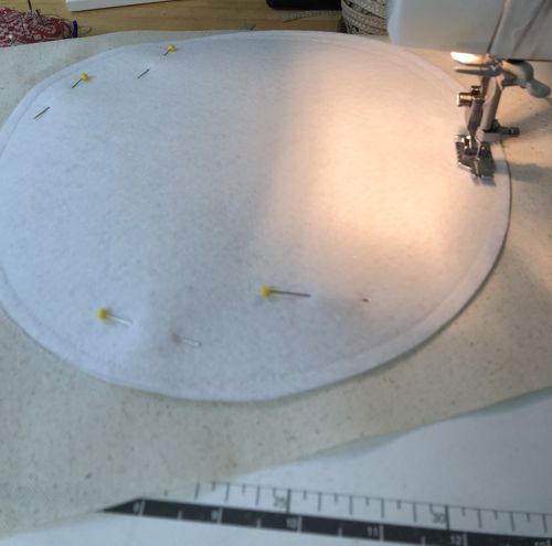 The felt circle is stitched to the canvas.